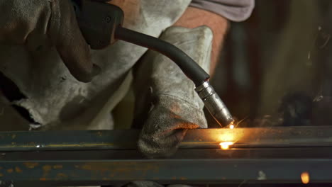 a man is engaged in welding iron at an industrial facility - close up