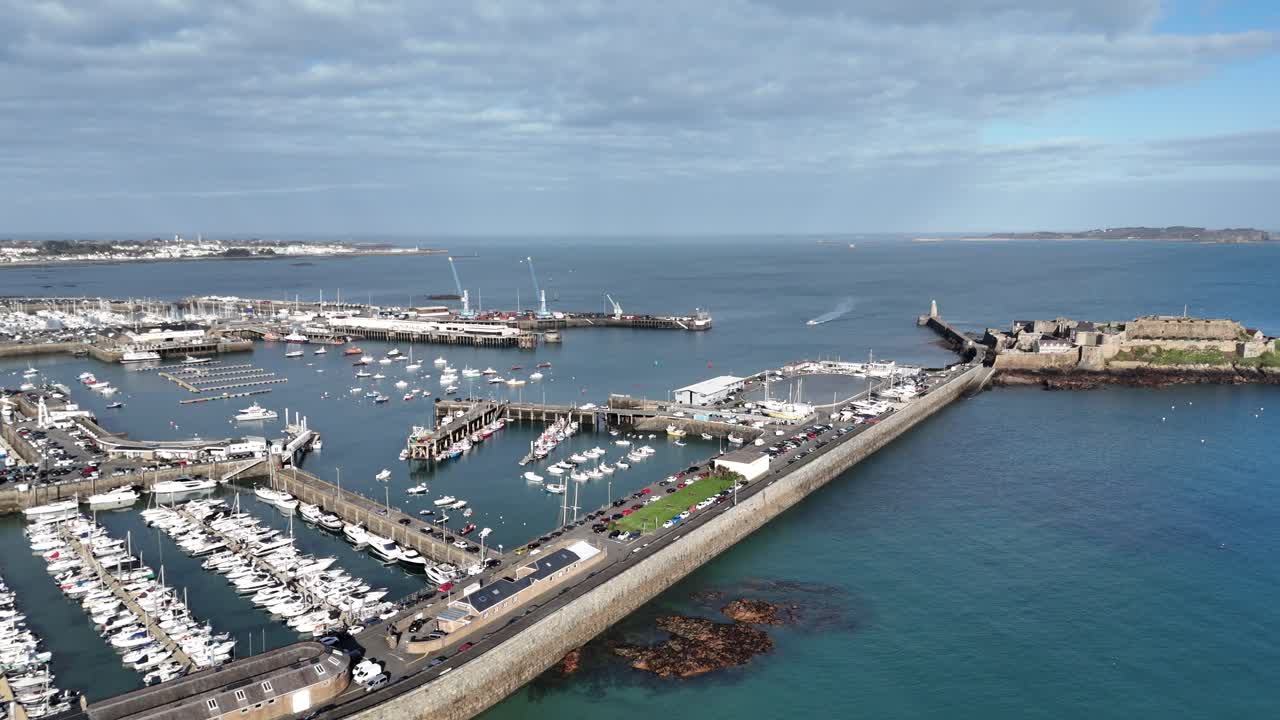 세인트 피터 포트 게른지 (st peter port guernsey) 는 캐슬 코네트 (castle cornet) 로 향하고 헤르마 (herm) 로 향하는 공중 촬영으로 상업적인 항구 페리 터미널과 마리나를 보여줍니다.