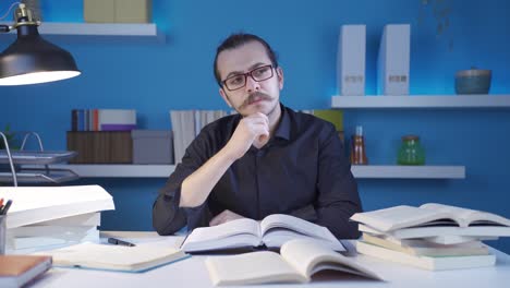 Thoughtful-historian-man-looking-at-books,-researching.