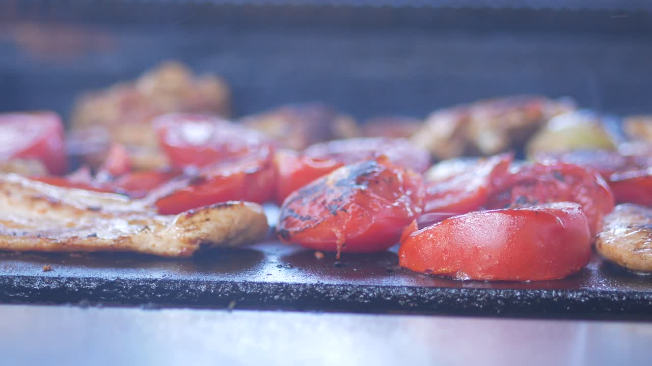 tomates a la parrilla y carne en una parrilla caliente