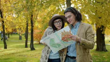 couple exploring a city park with a map in autumn