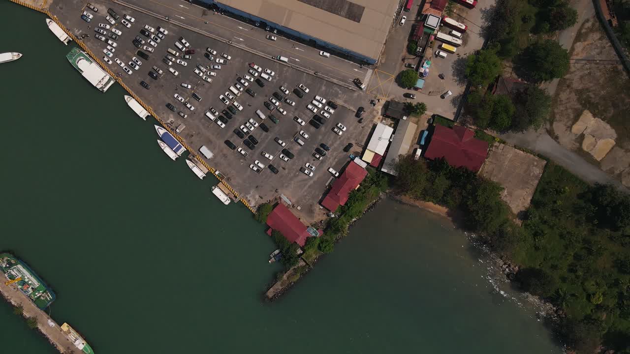varios barcos están amarrados en el muelle junto a un gran estacionamiento en sihanoukville en camboya