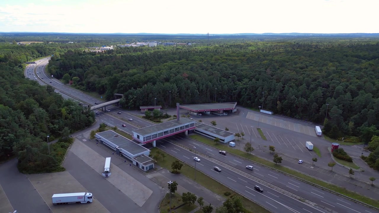 Rasteplass langs motorveien med biler som kjører på en flersporet motorvei. Panorama-droneopptak i bane.