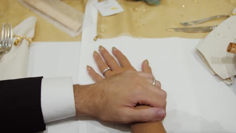una toma por encima del hombro de un novio poniendo su mano en el brazo de su esposa mostrando amor