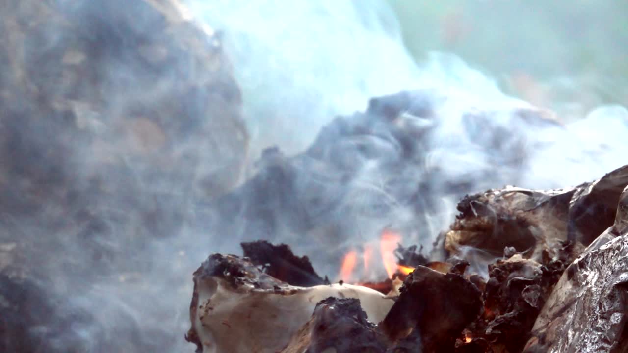 쓰레기 더미에서 느린 움직임으로 불타는 불은 대기 오염에 영향을 미니다.