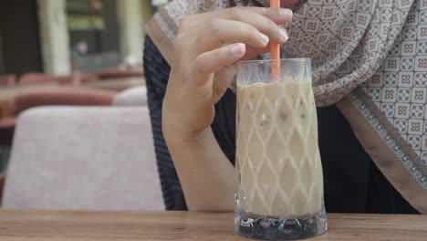 mujer disfrutando de un café helado en una cafetería