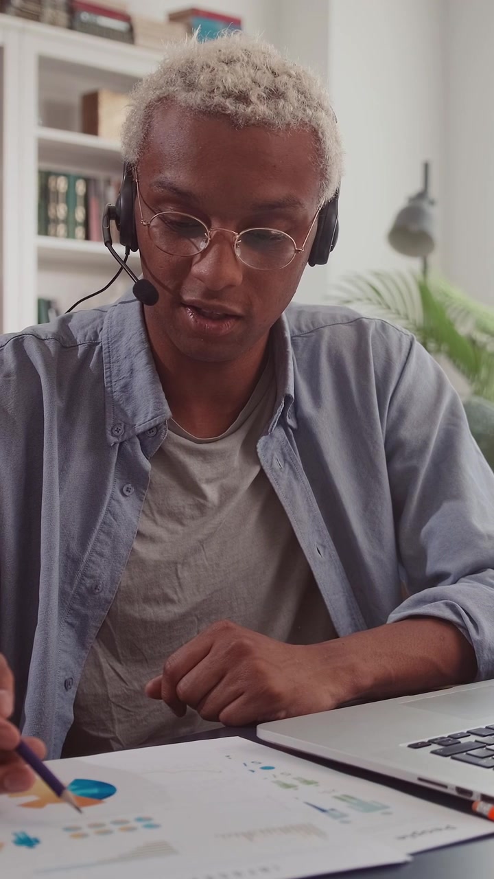 Profesjonell afroamerikansk mann med headset forklarer diagrammer