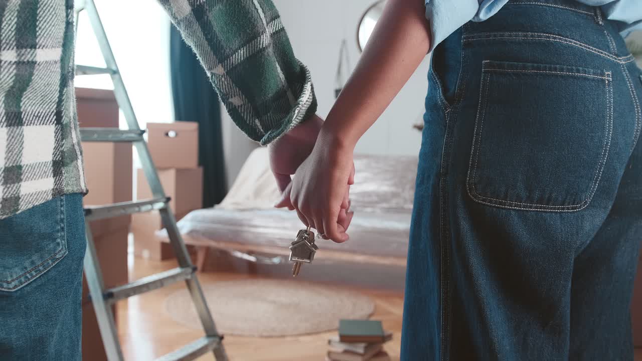 Close up hands of couple with keys to new house after relocating