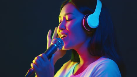 woman singing with headphones and microphone