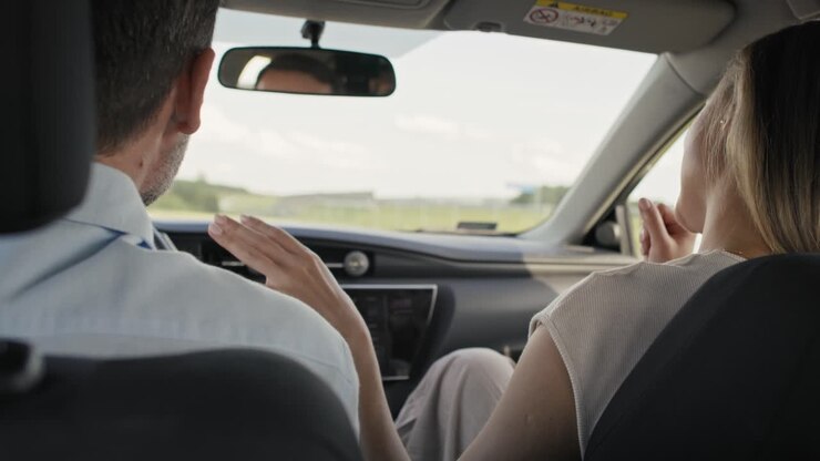 Vista posteriore di una allegra coppia caucasica di mezza età che canta durante un viaggio in auto