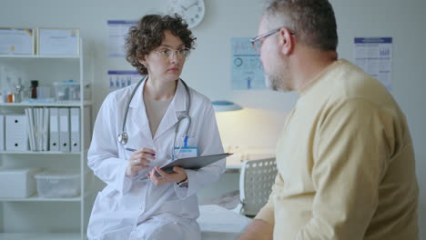 female doctor questioning patient and taking notes during medical check-up