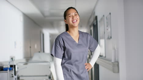 portrait of happy asian female doctor wearing scrubs in hospital, slow motion