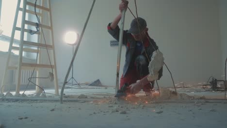 dismantling of metal structures in the room. master locksmith dismantles metal parts by cutting metal with a tool.