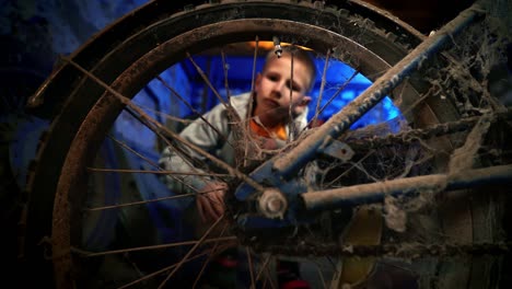 a kid admires the forgotten vintage bicycle. old-fashioned cycle. nostalgia.