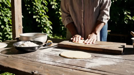 woman making pizza dough outdoors