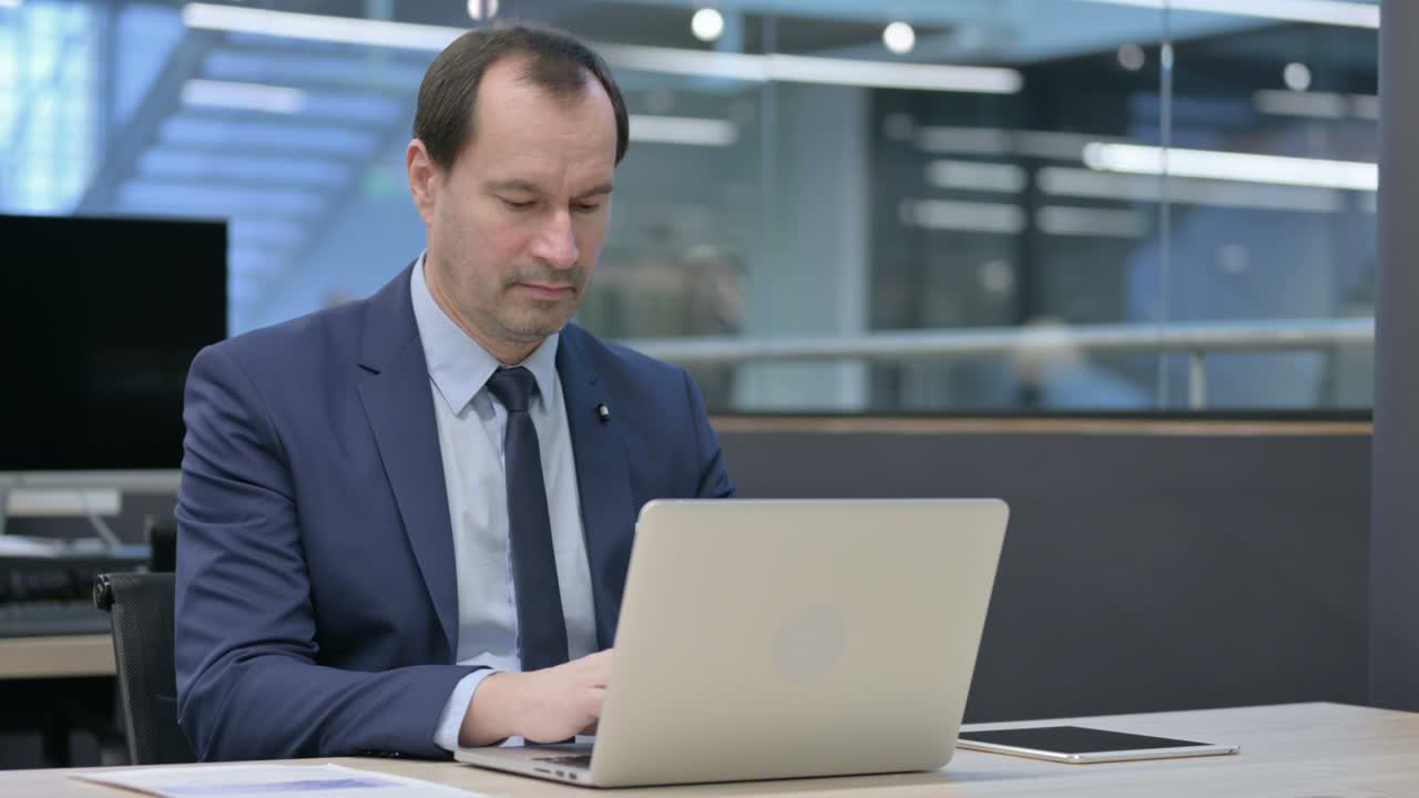 Businessman Working on Laptop in Office