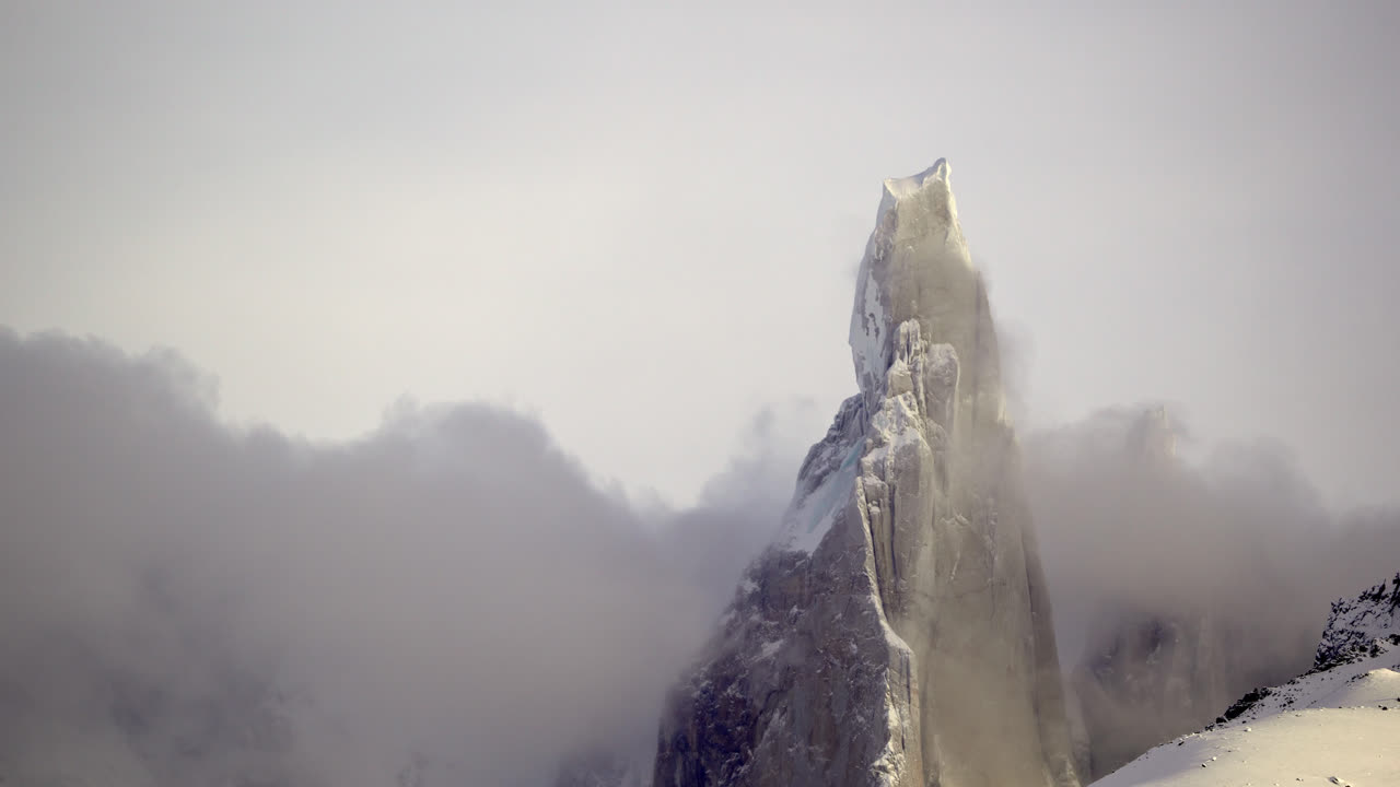 Film poklatkowy Cerro Torre wznoszącego się ponad przesuwającymi się chmurami w Patagonii. Niesamowity górski krajobraz ukazujący jeden z najbardziej charakterystycznych szczytów w Andach Patagońskich