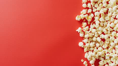 video of close up of popcorn on red background