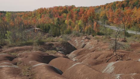 asombrosa formación de colinas de arcilla en las tierras baldías de cheltenham rodeadas de bosques de colores brillantes de hojas otoñales en caledon, ontario, canadá