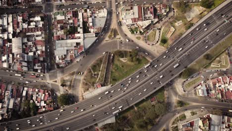 una toma aérea ascendente dinámica de arriba hacia abajo sobre una carretera transitada en la parte superior de una rotonda