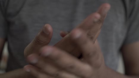 primer plano de un macho asiático adulto masajeando y frotándose las manos
