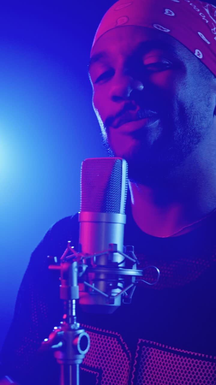 Man singing into a microphone wearing a bandana
