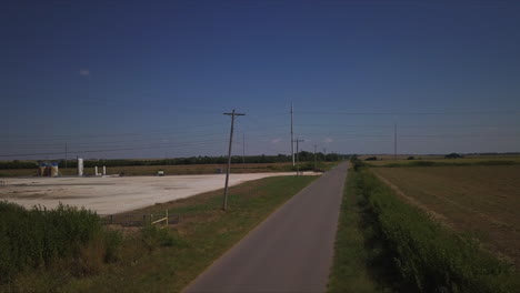 Aerial-descending-shot-of-an-antique-car-driving-along-a-country-road