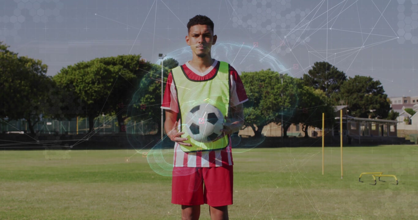 Male soccer player rotating ball preparing for training while digital animation showing performance