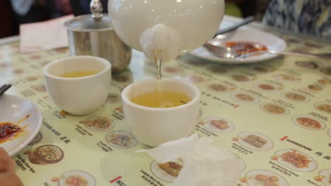 Oolong-green-tea-being-served-using-kettle-in-Chinese-porcelain-cup