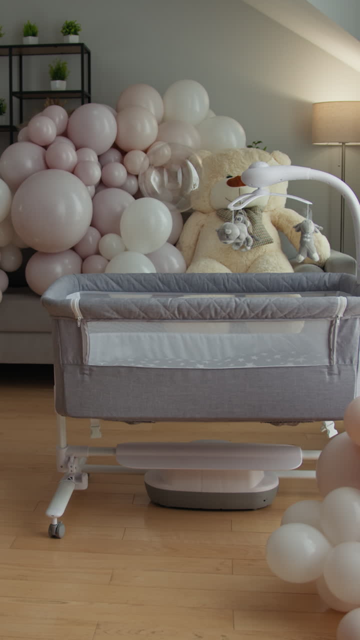 Culla per neonati di colore neutro con orsetto di peluche e palloncini sullo sfondo, in preparazione per il neonato.