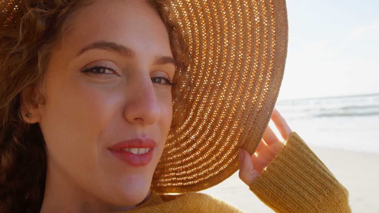 Donna felice con il cappello in spiaggia 4K