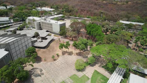 drone view of universidad central de venezuela campus with trees and distant cityscape