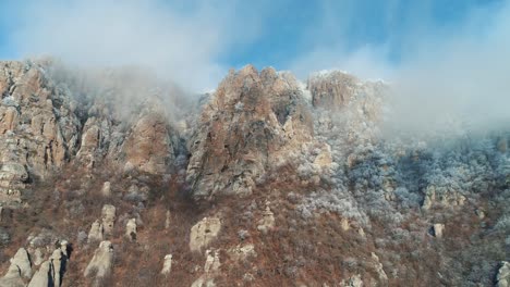 snowy mountain peaks with fog and clouds