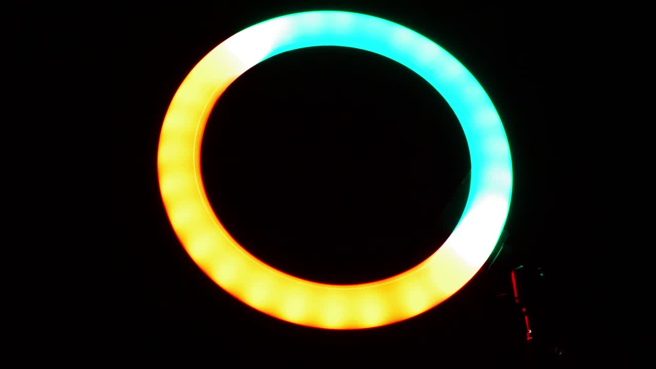 Luminous ring rgb lamp. Multicolored light in a dark room, close-up.