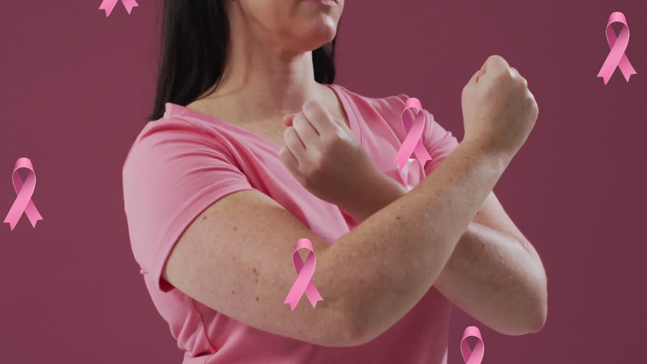 Animation of pink ribbons over caucasian woman with pink ribbon on pink background
