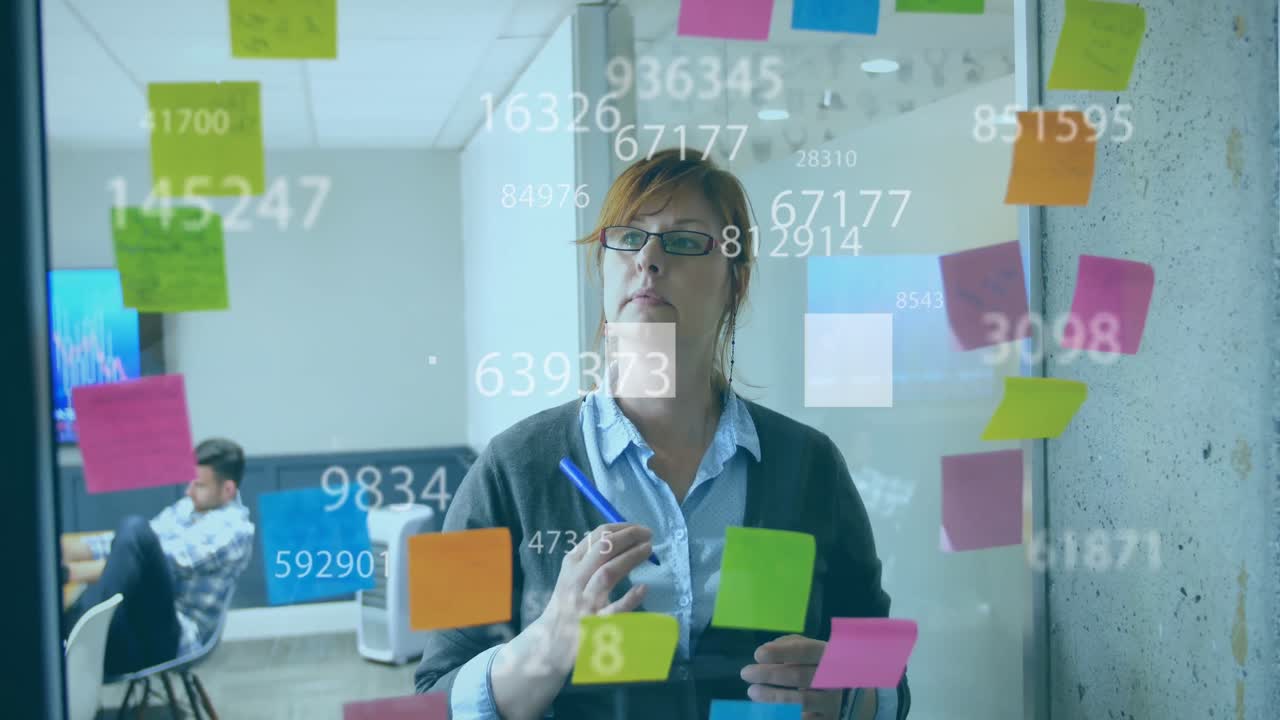 Animation of changing numbers and squares over caucasian woman writing ideas on sticky notes