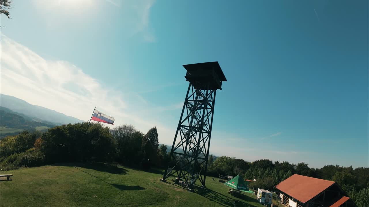 FPV drone follows a person walking towards a border observation tower in Slovenia-Austria region