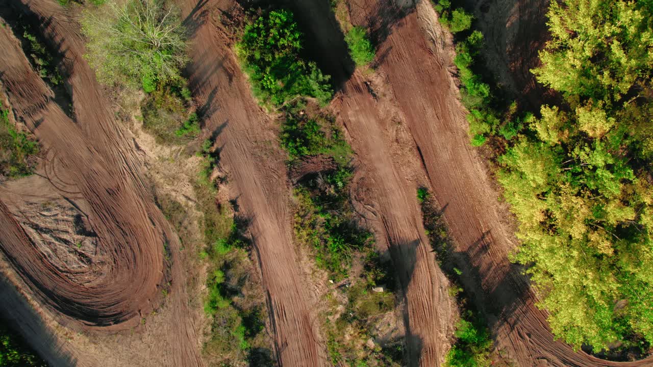 arriba hacia abajo antena giratoria por encima de los pilotos de motocross que conducen fuera de la carretera en pistas de bicicletas de tierra