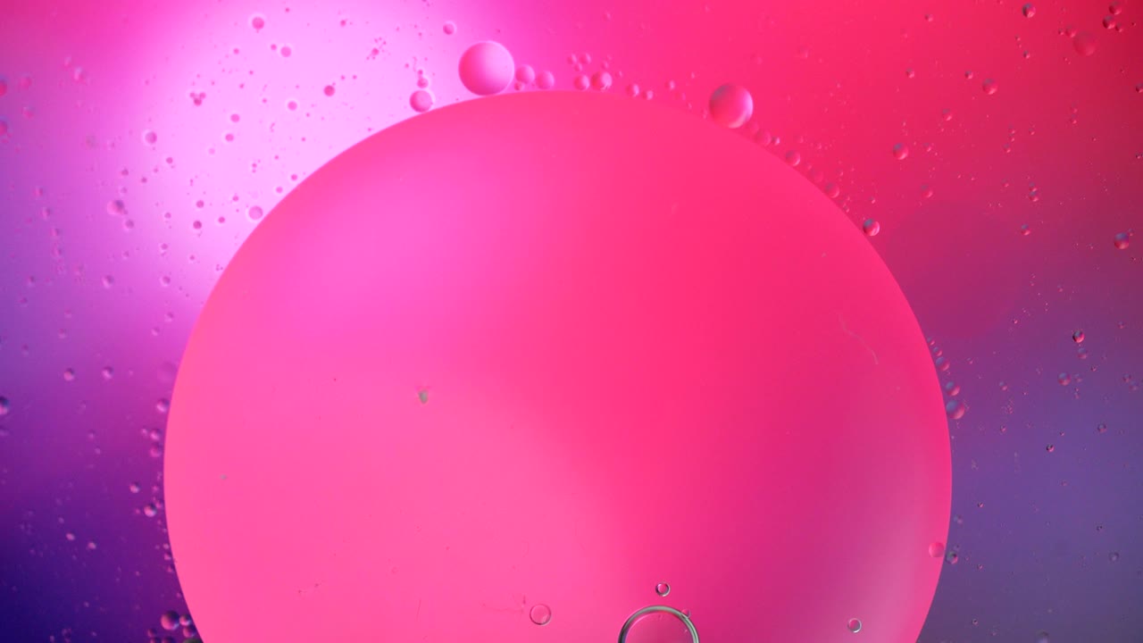 Fantastic structure of colorful bubbles. Chaotic motion. Abstract colorful paint. Top view. Movement of bubbles in the liquid. Oil surface multicolored background. Macro