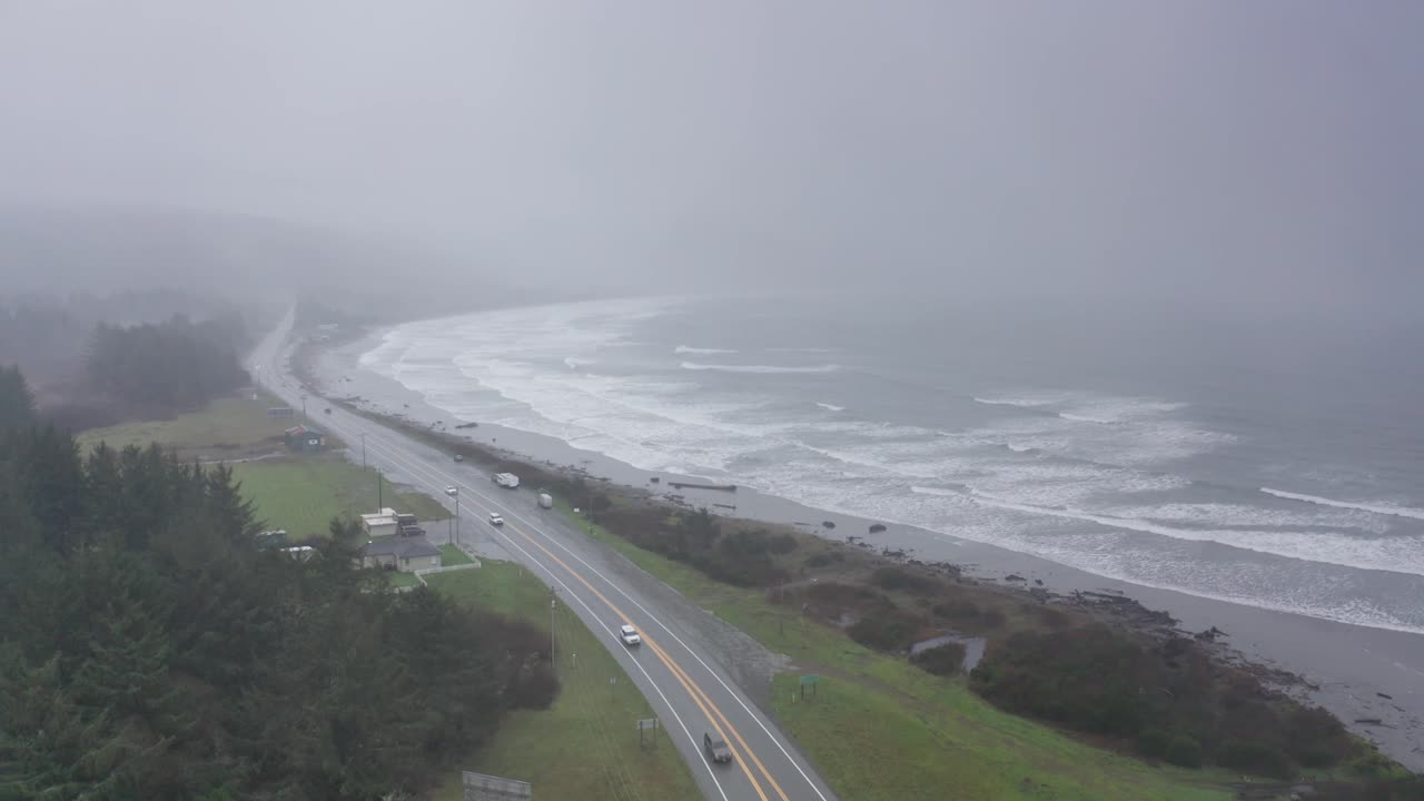 Aerial descending and panning shot of Crescent Beach along the Redwood Highway during stormy weather in Crescent City, California. 4K