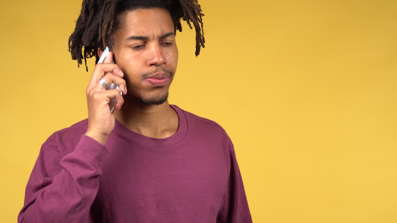 Youn afro american man has a phone call and disappointed what he hear