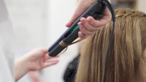 close-up shot of a woman having her hair straightened in hair salon