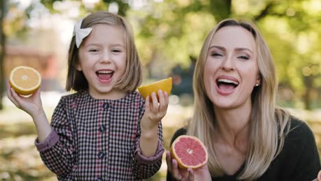 Handheld-view-of-mother-and-daughter-having-fun-with-fruit