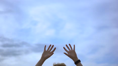 manos levantadas hacia el cielo