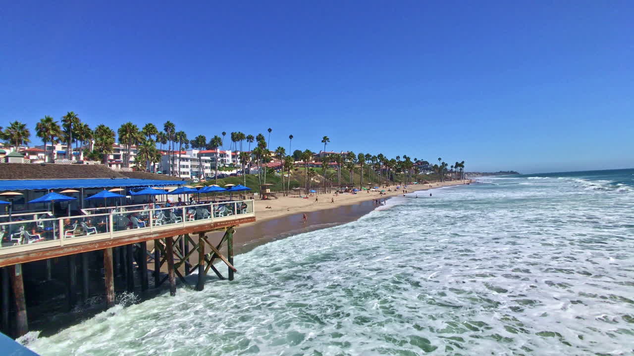 Onde che si infrangono lungo la costa del molo di San Clemente. L'alta marea mostra una grande quantità di acqua verde