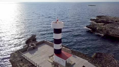 imágenes de drones del faro en sant jordi, mallorca, españa con olas azules