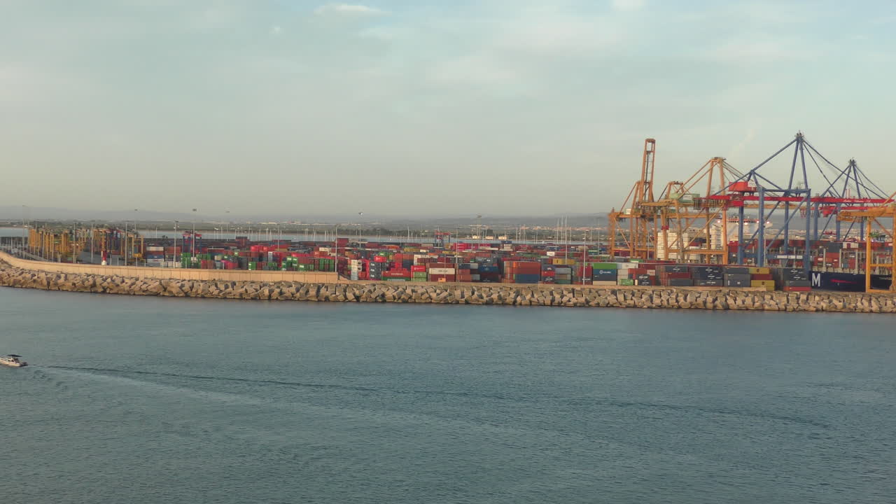 There are many containers and cranes in the port of Barcelona