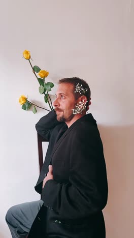 hombre con una chaqueta negra con rosas amarillas y flores