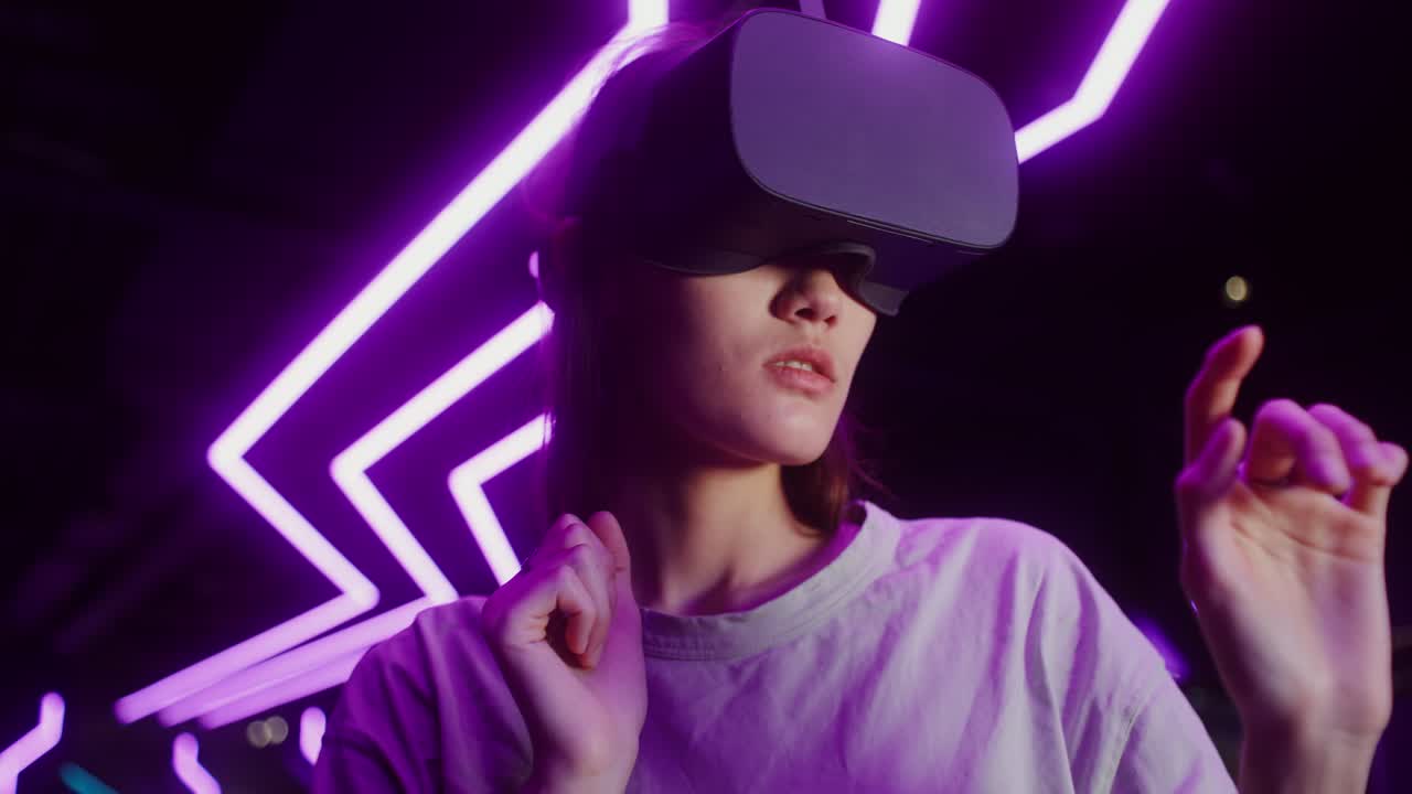 Woman exploring virtual reality with VR headset in neon-lit environment