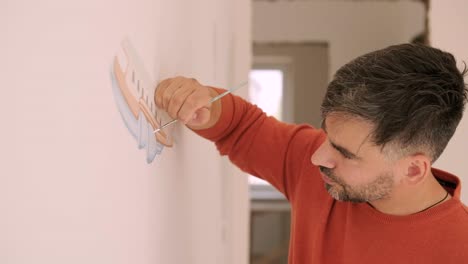 el artista está decorando las paredes con dibujos en la habitación de los niños. pintura de arte de las paredes en la casa nueva. trabajos de reparación.